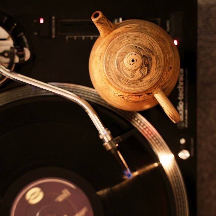 Conversation over a tea board beside a wooden sound system