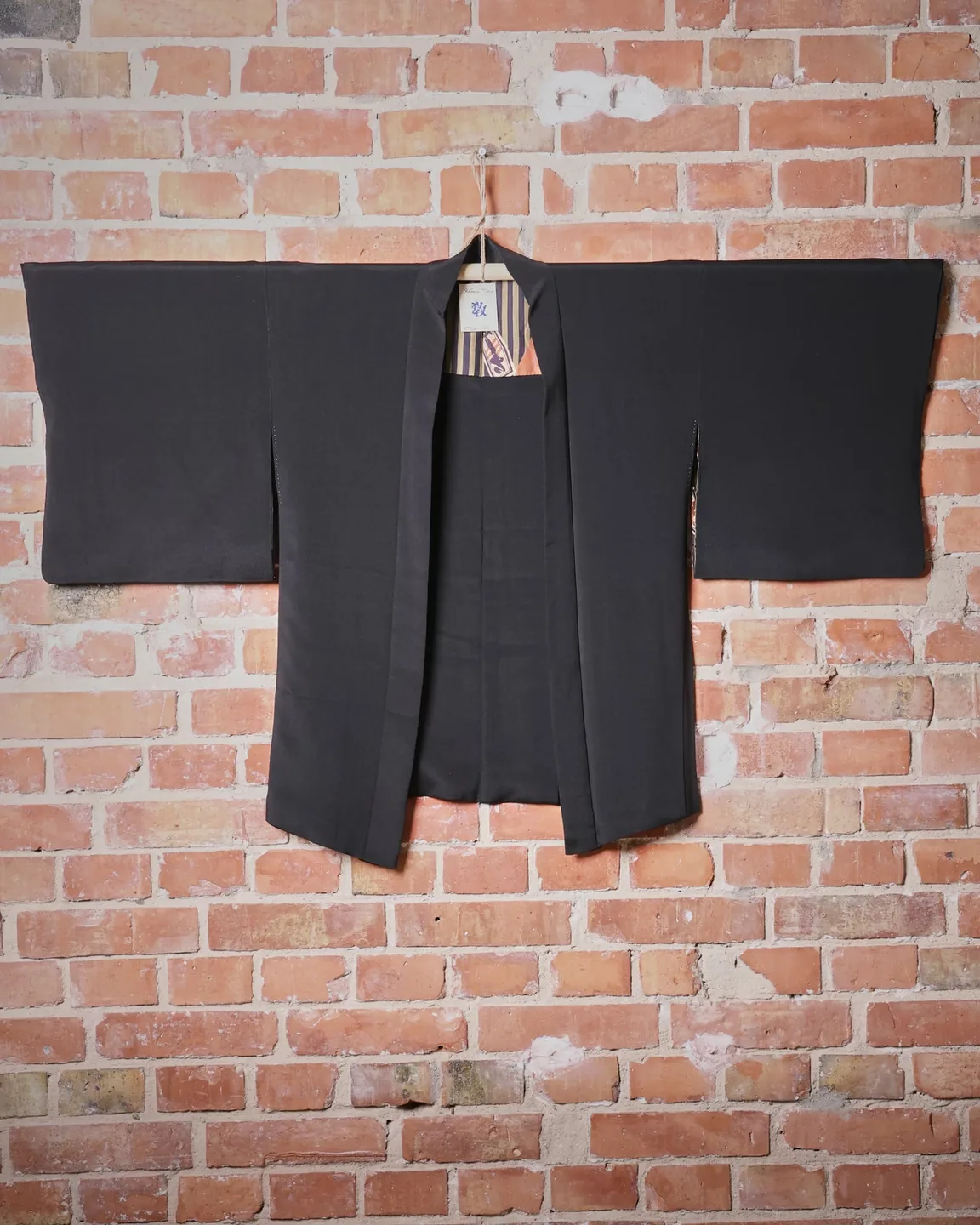 Black haori with white crests and striped lining — view 1