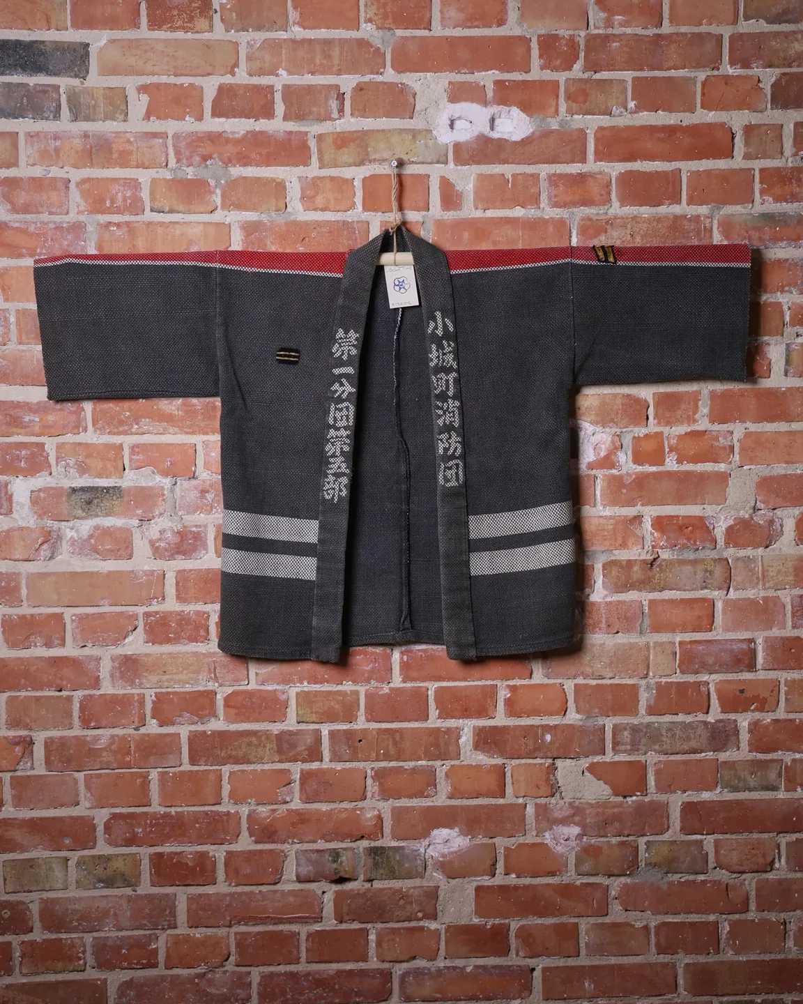 Dark jacket with lettering and red trim — view 1